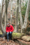 Andy seated on a log looking at a blurred Harley