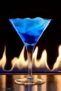 Fire behind a blue cocktail