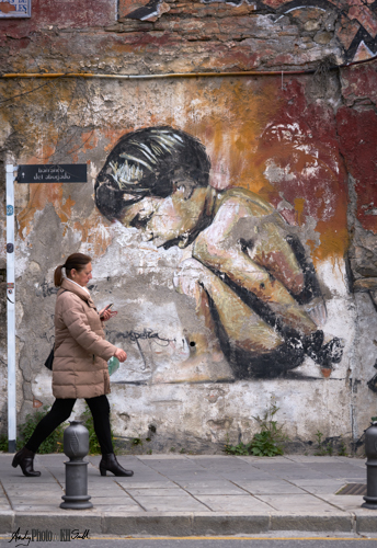 Woman in front of graffito of young boy