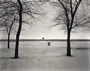 Minimalist shot of park in show wife and daughter in background