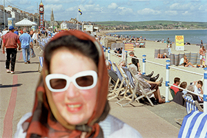 Blurry woman in front of a summer seaside scene