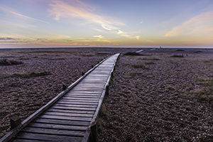 Long walkway to a distant photographer, colourful sunrise