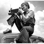 Dorothea Lange on top of am old car