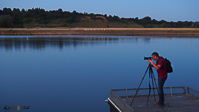 Photographer Camera on Tripod on pontoon on River Blue Sky