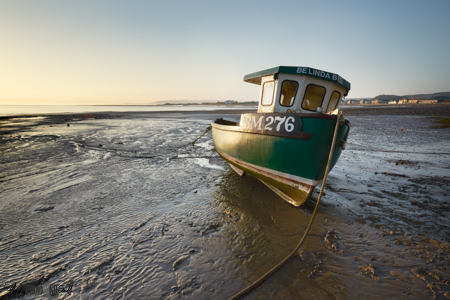 Fishing boat on the mud flats of Minehead at sunrise