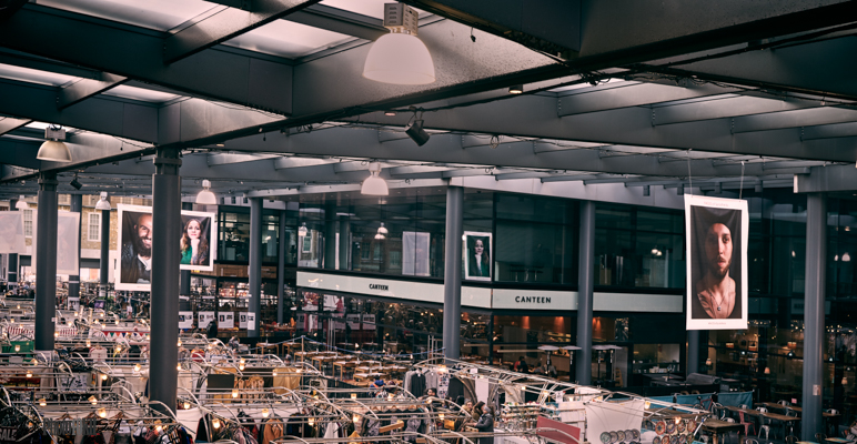 Large posters of characters from Spitalfields hanging over the market