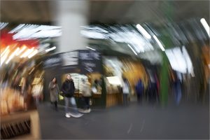 Impressionist image of man in blurred market