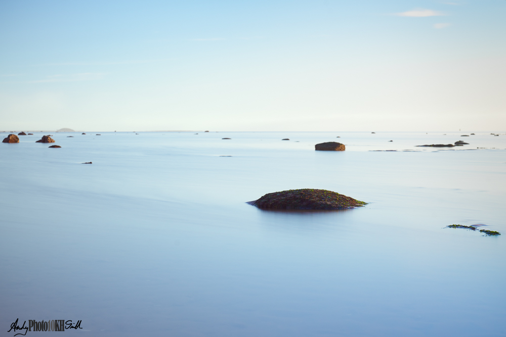 Rocks in the sea with smooth water resulting from a slow shutter speed