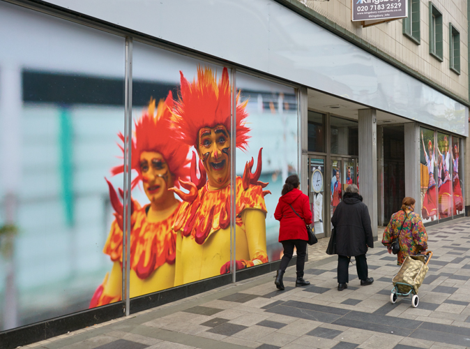 Laughing clowns looking at three shoppers