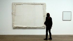 Woman in black standing in front of a pure white painting