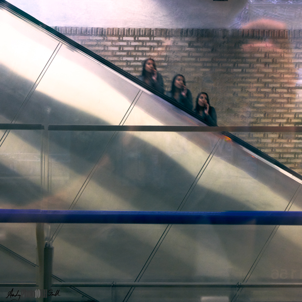 Triple exposure of woman on the phose on an escalator