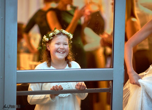 Sweet little girl at window with bride's arm during a wedding party