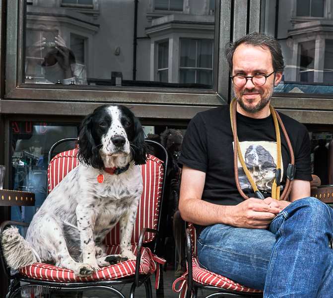Man in dog t-shirt with dog in cafe