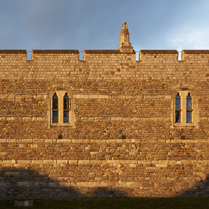 Pair of windows and chimney in castle wall golden and blue sky