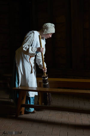 Maid sweeping with wooden brush